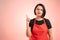 Woman employed at supermarket with red apron and black t-shirt thinking of an idea