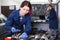 Woman employee is choosing instruments for repair car
