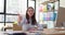 Woman employee shows thumbs up sitting at desk in office