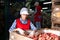 Woman employee working at a fruit warehouse, preparing a peaches for packaging