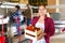 Woman engaged on fruit sorting line, carrying box with strawberry in storage