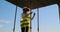 A woman engineer at a construction site in virtual reality glasses moves her hands simulating the work of the interface