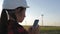 Woman engineer working in wind turbine electricity industrial at sunset.