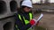 Woman engineer writing near concrete blocks