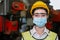 Woman engineering wear protection face mask and safety helmet holding standing front machine in factory Industrial.