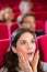 Woman engrossed in cinema film shocked expression on face