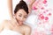 Woman enjoy receiving face massage at spa with roses