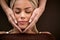 Woman enjoying during facial massage in cosmetic salon