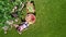 Woman enjoying food in beautiful roses garden, aerial top view from above of girl eating and drinking in park