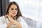 Woman enjoying morning awakening in a soft snow-white bed