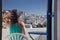 woman enjoying mykonos town view from terrace, Greece - summer holiday