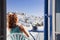 woman enjoying mykonos town view from terrace, Greece - summer holiday