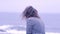 Woman enjoying the rain on the beach on a gray rainy day.