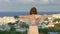 Woman enjoying sea breeze on hill, looking at seaside town. Feeling of freedom