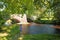 Woman enjoying the shade, under the trees by Bampton Grange.