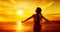 Woman enjoying Sunset. Women Rear View Silhouette Arms Outstretched looking away at Sea, Sun. Spiritual Relaxation and Meditation