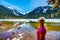 Woman enjoying the view of the partly frozen Lower Joffre Lake and the Matier Glacier