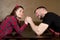 A woman enjoys an easy fight in arm wrestling with her husband at home
