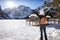 A woman enjoys the view to the frozen Lago di Braies in the Italian Dolomites mountains