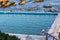 Woman entering seaside ocean swimming pool set against calm blue water and large exposed rocks