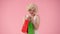 Woman enthusiastically says wow and shows colorful shopping bags. Woman looking like marilyn monroe with red and green