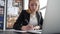 Woman entrepreneur writing with pen business document on table in modern office