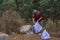 woman environmentalist with garbage bags picking up garbage from the field