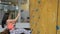 Woman in equipment for bouldering jumps down an artificial rock wall.