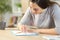 Woman erasing with rubber on a desk at home