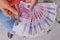 Woman with euro in her hands thinking about the repair of a new flat, close up. Girl holding money and trying to arrange furniture