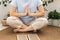 Woman of European appearance sits in lotus position with wooden sadhu board nails for sadhu practice.