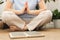 Woman of European appearance sits in lotus position with wooden sadhu board nails for sadhu practice.