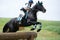 Woman eventer on horse jumping overcomes the Log f