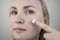 A woman examines dry skin on her face. Peeling, coarsening, discomfort, skin sensitivity. Patient at the appointment of a