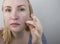 A woman examines dry skin on her face. Peeling, coarsening, discomfort, skin sensitivity. Patient at the appointment of a