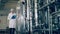 A woman examines tanks at a dairy plant. Quality control of production line at a factory.