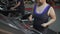 Woman with excess weight running fast on treadmill, working hard for slim body