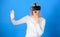 Woman excited using 3d goggles. Woman wearing virtual reality goggles in blue background. Woman using virtual reality