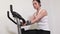 Woman on exercise bike finish doing workout and check blood pressure