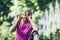 Woman exercising in park while listening to music. Mature woman resting after exercise