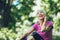 Woman exercising in park while listening to music. Mature woman resting after exercise