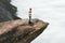 Woman explorer walking on Trolltunga rocky cliff in Norway