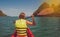 Woman exploring calm tropical bay with limestone mountains by kayak