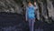 Woman exploring cave on Reynisfjara beach near Vik, Icealnd