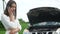 Woman expresses bewilderment when she looks under hood of car