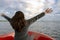 Woman extending arms and enjoy on the boat and looking forward into lagoon