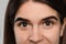 Woman during eyebrow tinting procedure on grey background, closeup