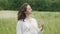 Woman with eyes closed standing in field feeling wind and oneness with nature