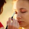 Woman face applying eyeshadow eyes makeup.