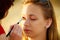 Woman face applying eyeshadow eyes makeup.